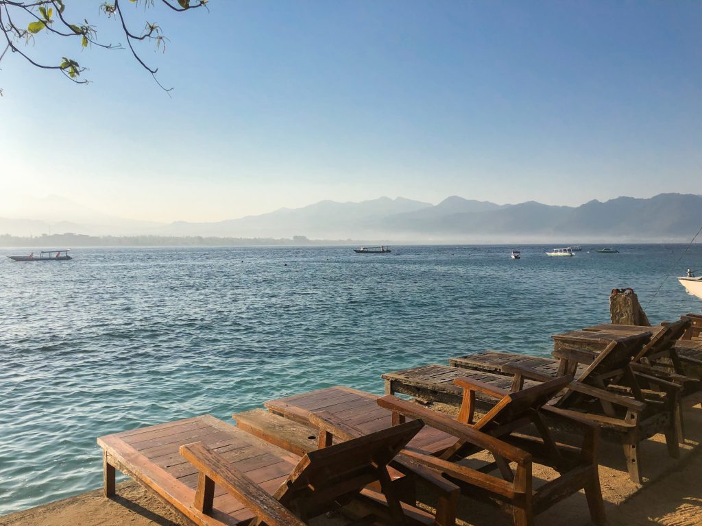 ocean view with sun loungers and mountains of lombok in the background