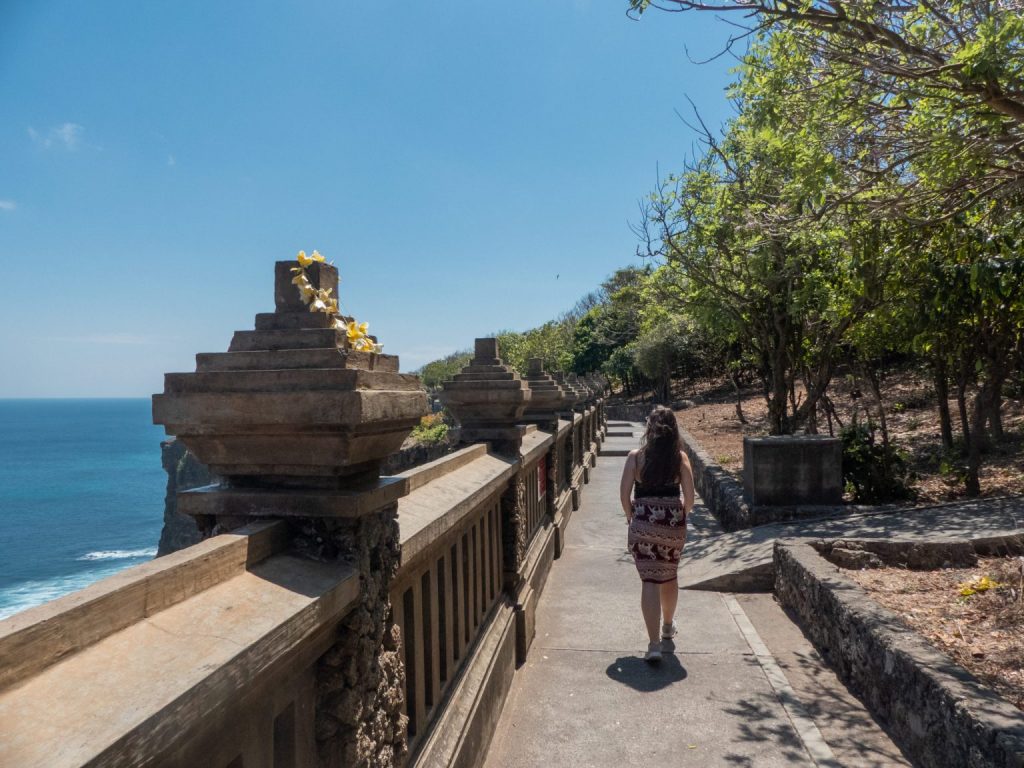 girl walking along cliffs at uluwatu temple on day trip