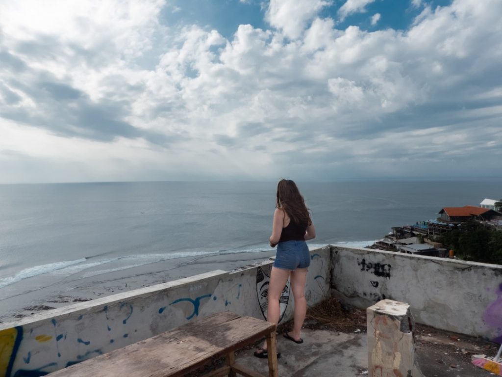 girl standing on roof of abandoned villa with oean views