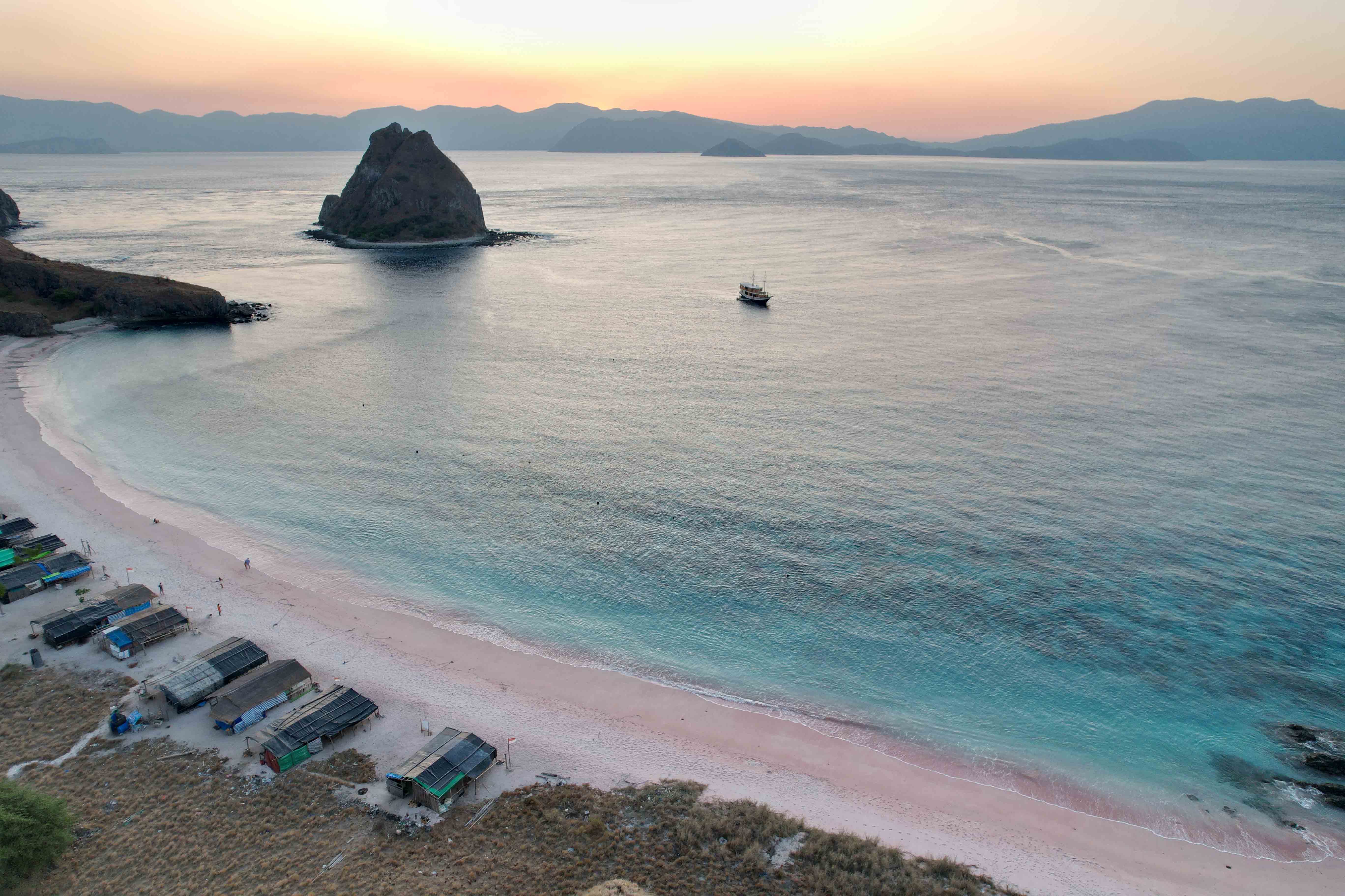 pink beach sunset drone birdseye view mountain backdrop