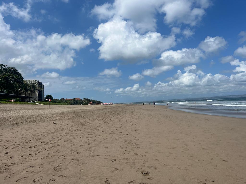 beach in seminyak with blue sky on the way from the walk from canggu during low tide