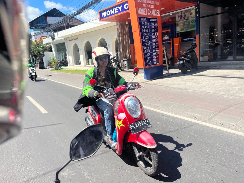 bali sidewalk gojek driver on a red bike