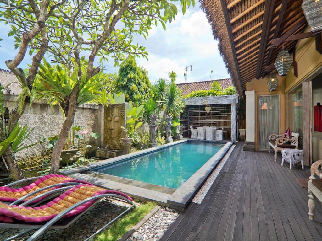 terrace with pool sunbeds dining tables surrounded by plants 