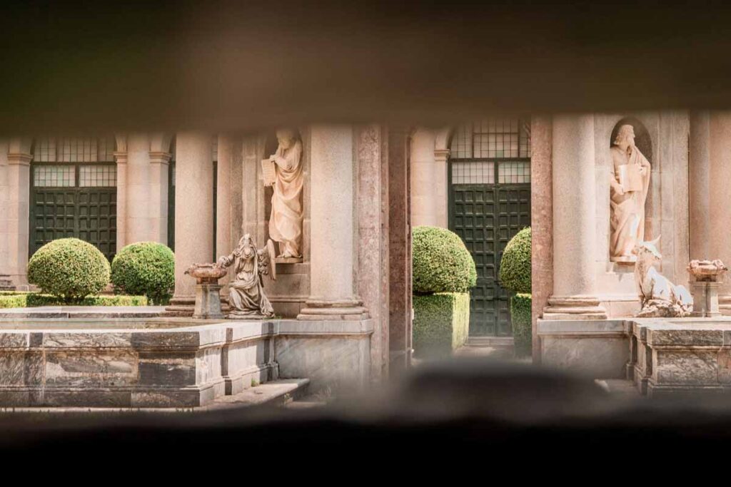 Courtyard with mable sculptures and green bushes 