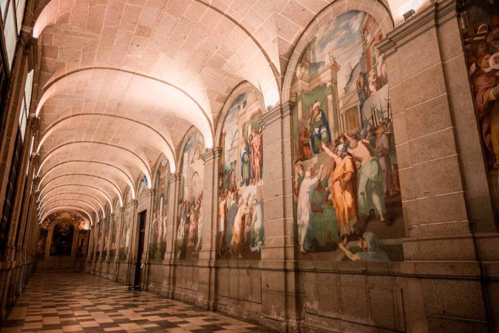 paintings in a hallway lighting historical architecture in Spain