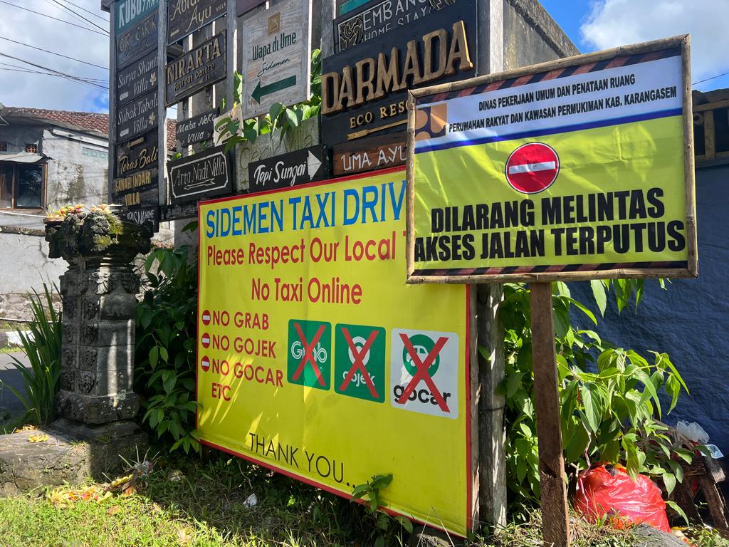 yellow no gojek signs in sidemen bali with posters