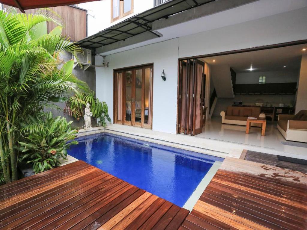 wooden terrace with swimming pool and view of the villa's living room 