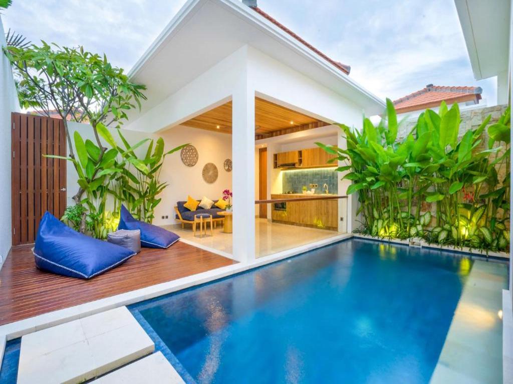 swimming pool with terrace, lounge and outdoor kitchens surrounded by vegetation 