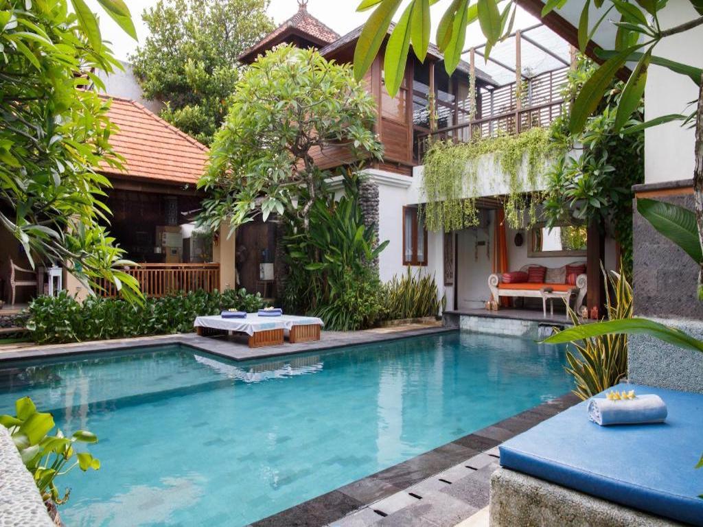 spacious villa with patio, sunloungers surrounded by green garden