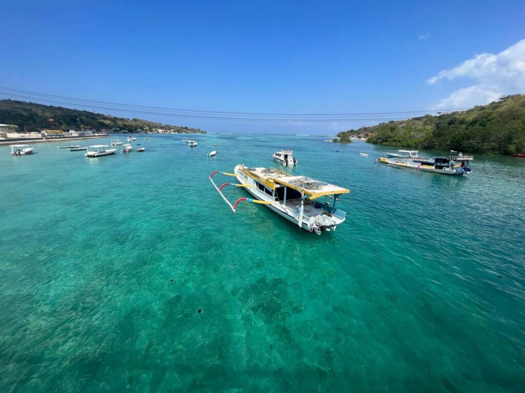 nusa lembongan and ceningan lagoon with white boat and blue water