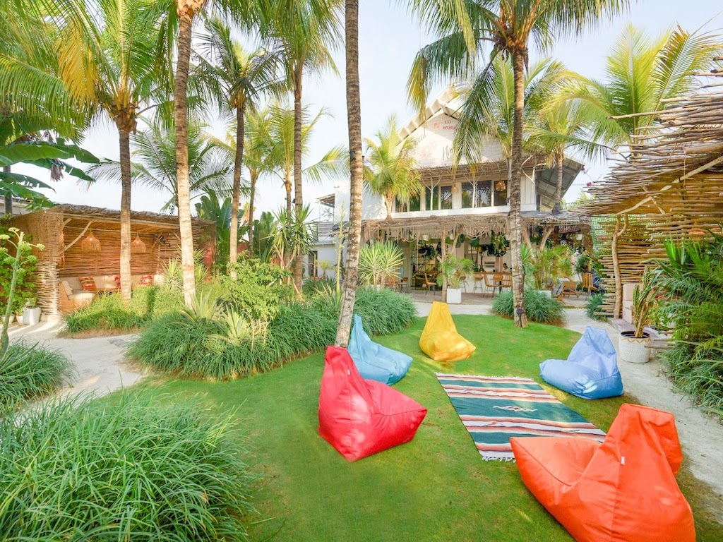 garden surrounded by greenery with tables and sofas at one of the best coworking spaces in canggu