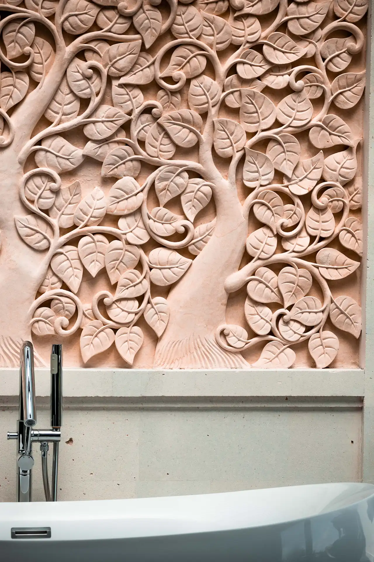 ornate wall carving beige bathtub