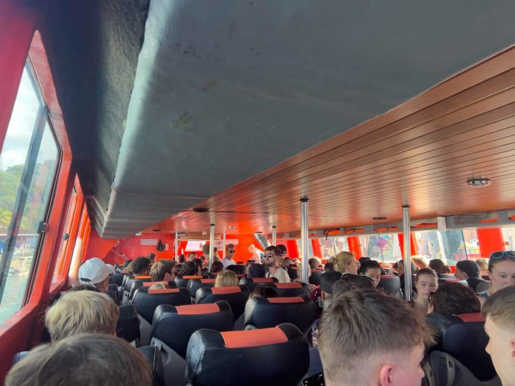 inside fast boat to gili trawangan with orange interior, people sitting and cramped conditions