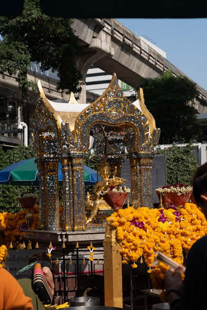 erawan shrine bangkok ask for a wish yellow flowers