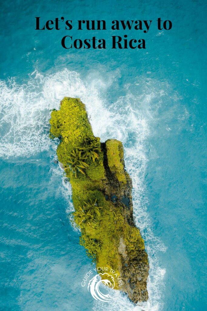 A moss-covered rock juts out into the ocean waves perfect for Costa Rica Instagram captions and quotes