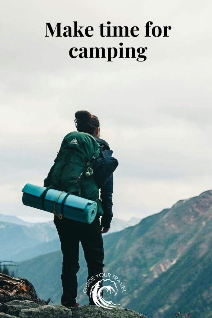 A hiker with a backpack gazes at mountain vistas for camping instagram captions and quotes.