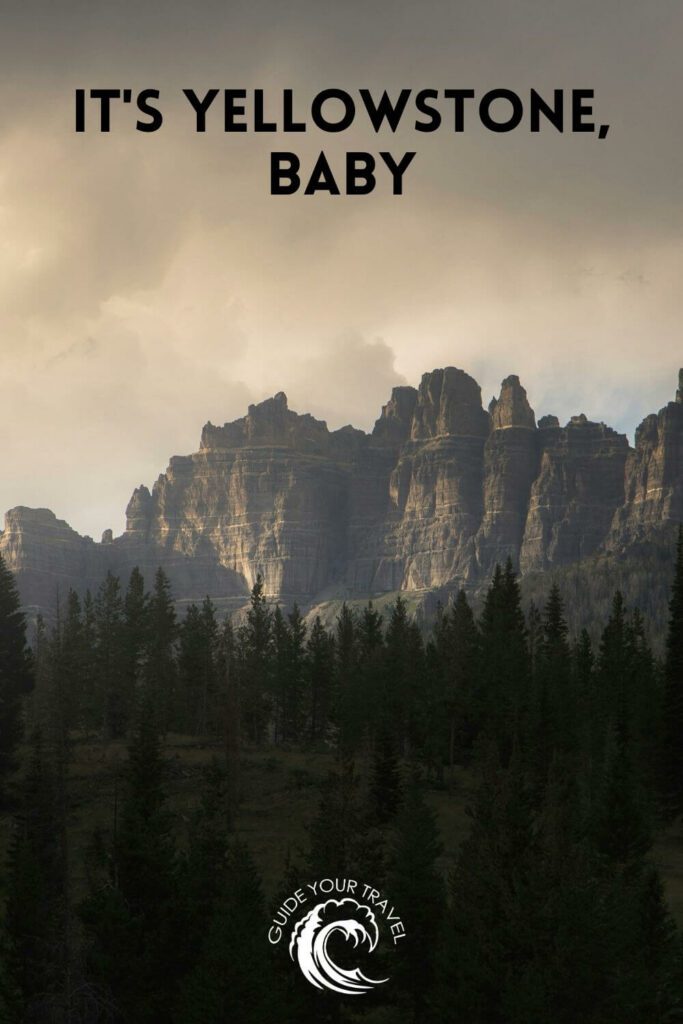 Rocky cliffs rise above a forested landscape in Yellowstone perfect for instagram captions and quotes