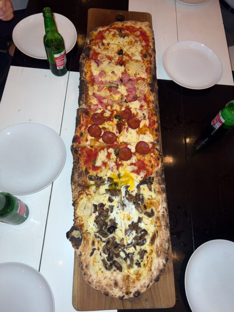 luigi's hot pizza long mixed pizza on table