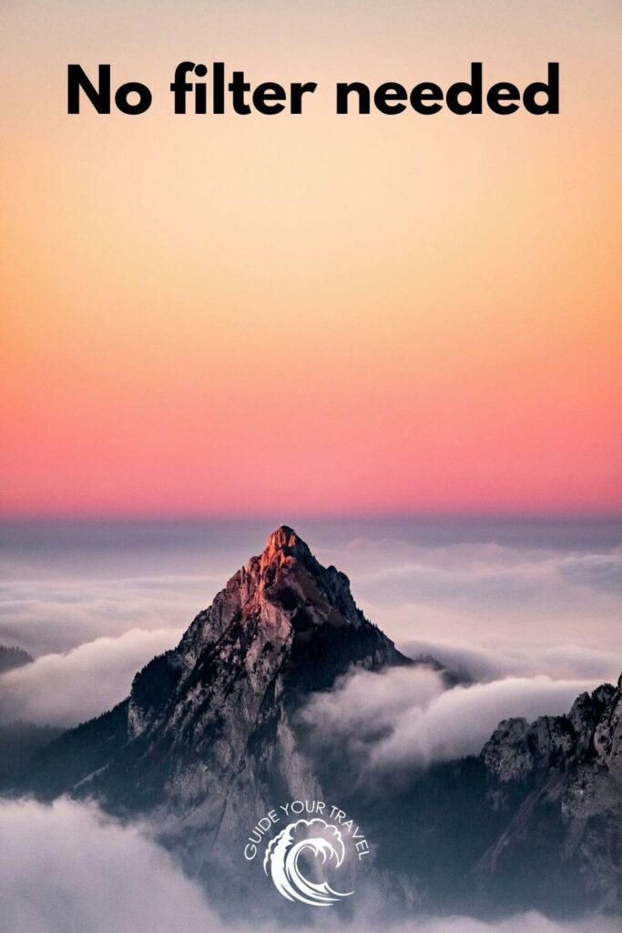 Mountain peak from a sea of clouds at sunset perfect for Sunset Instagram Captions and Quotes