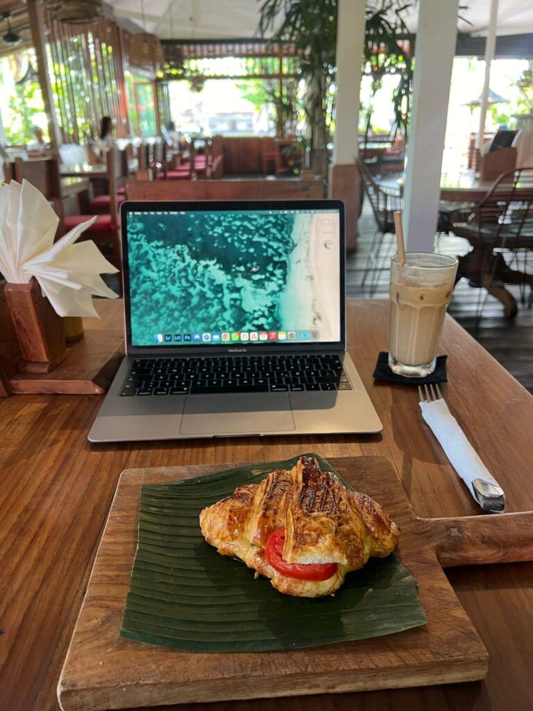 Tiga cheese and tomato croissant in front of laptop